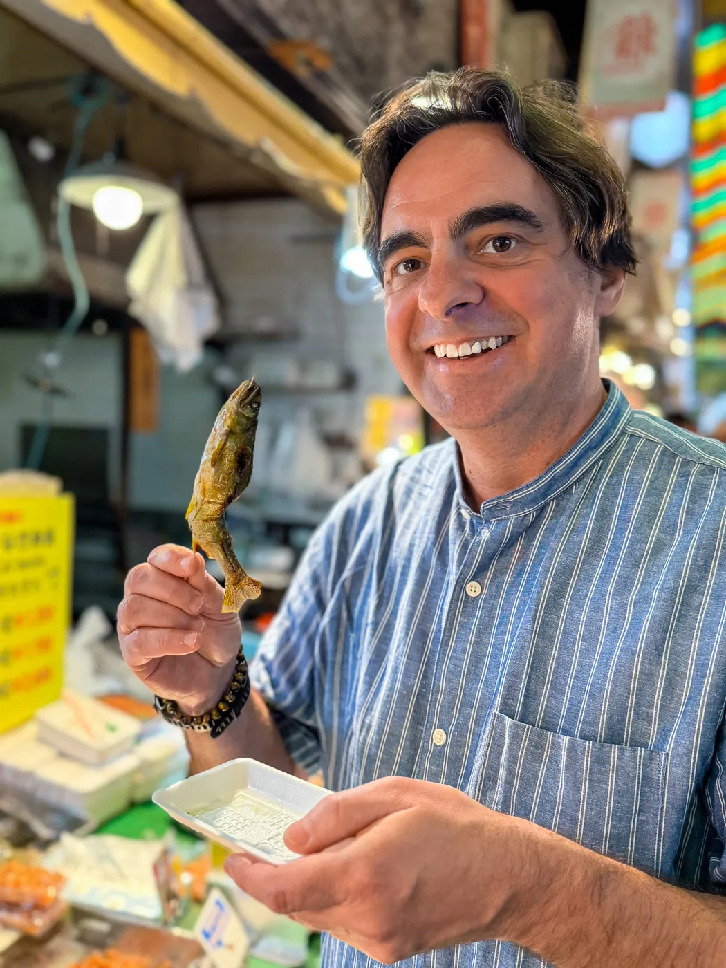 Chris P King from Food Tours Japan eating ayu Nishiki Market tour