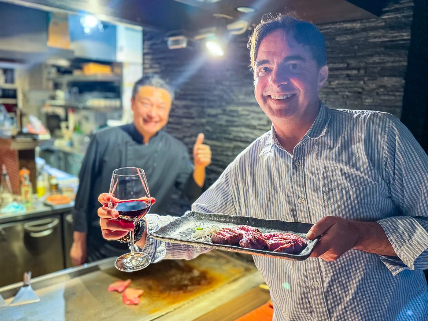 Me holding a plate of wagyu with the teppanyaki chef behind me