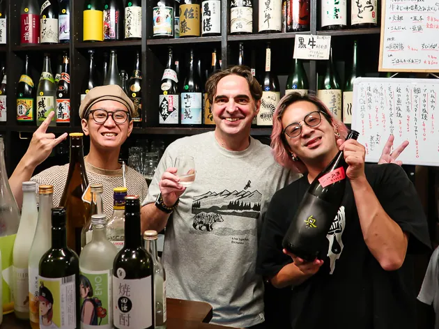 Me enjoying sake with izakaya owners on a Kyoto food tour