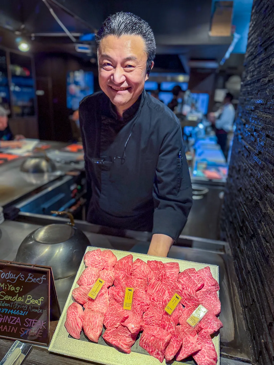 Chef presenting wagyu cuts at a teppanyaki restaurant in Tokyo